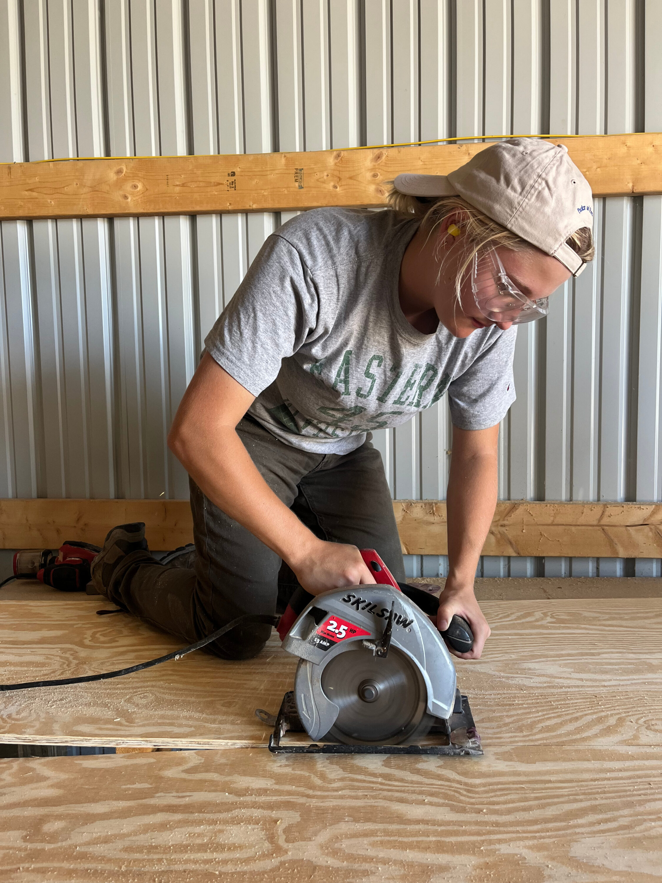 Meredith using a saw to cut wood